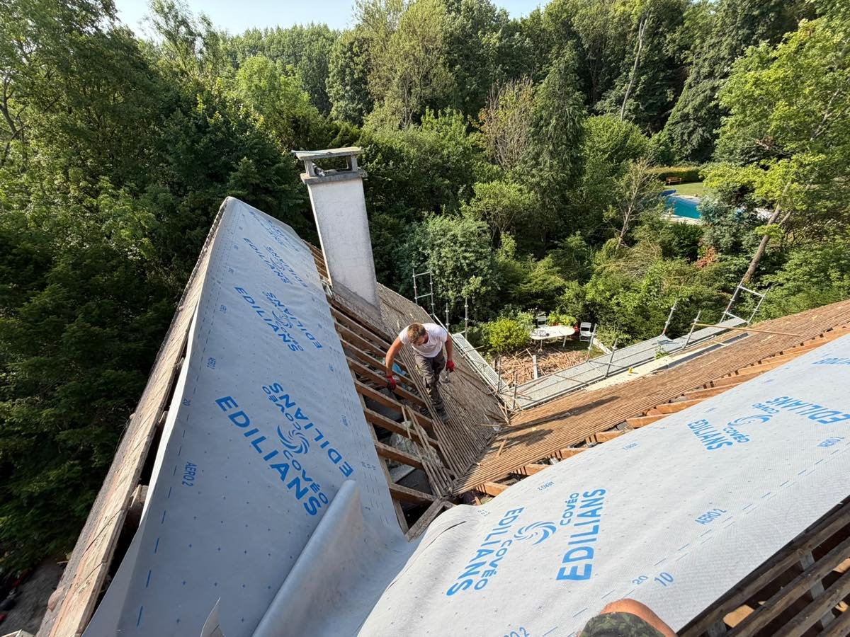 Écran de sous-toiture déroulé sur le versant, souche en zinc à côté