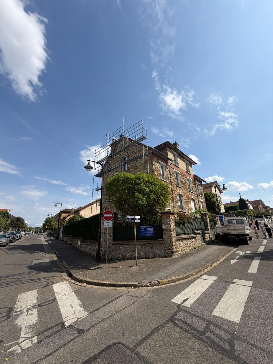Maison en meulière à l'angle d'une rue, échafaudage monté sur la toiture