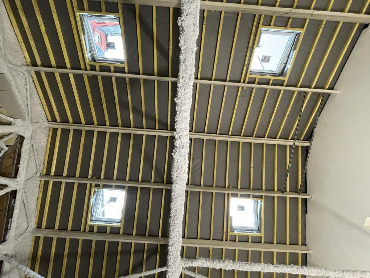 Quatre châssis de toit vus depuis l'intérieur, entre les chevrons