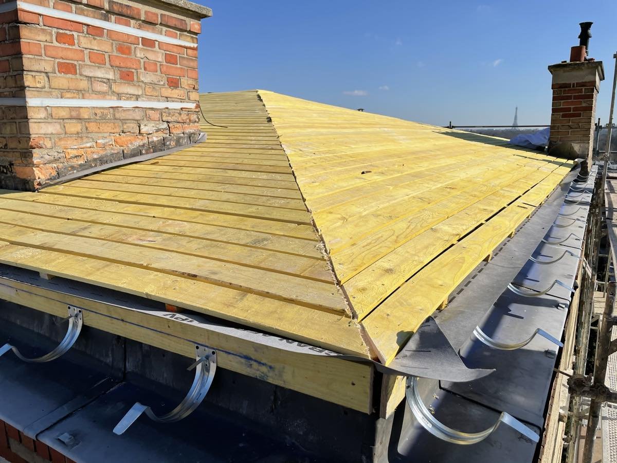 Gouttière zinc et crochets posés en pied de toiture, sous le voligeage neuf