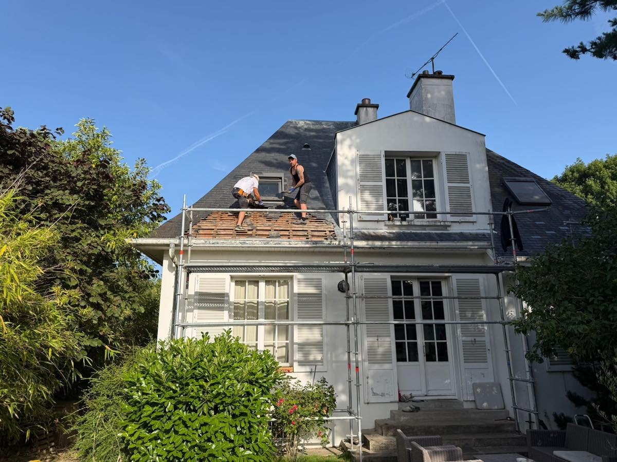 Deux couvreurs déposant l'ancienne couverture en ardoise