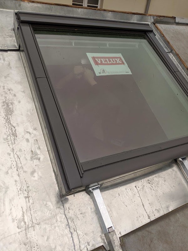 Fenêtre de toit posée sur une couverture zinc, film de protection encore en place
