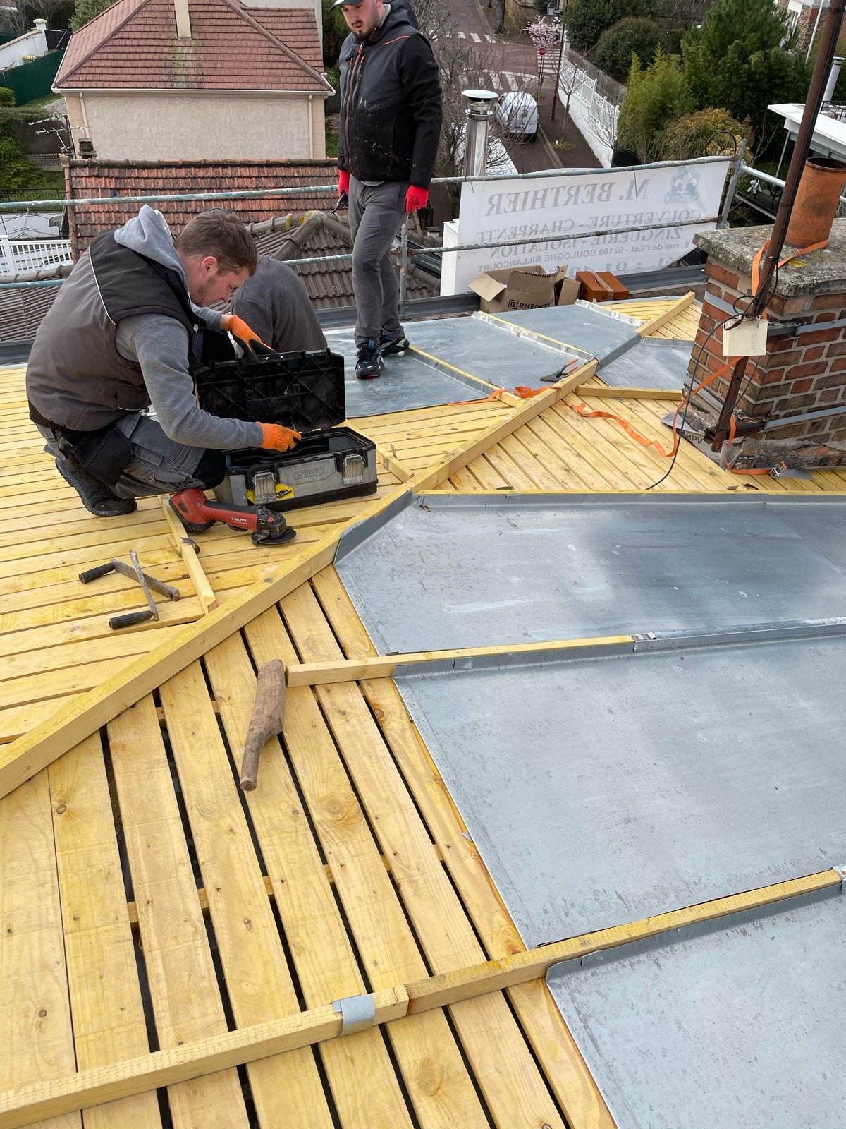 Couvreur façonnant les bacs zinc sur le chantier